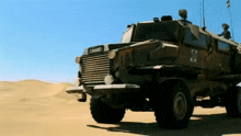 a military vehicle is parked in the middle of a desert