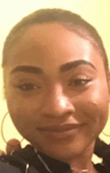 a close up of a woman 's face making a funny face while wearing hoop earrings .