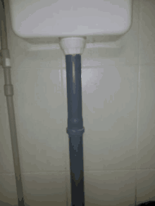 a white toilet with a gray pipe coming out of it