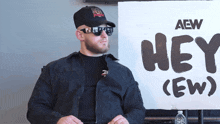 a man stands in front of a sign that says hey