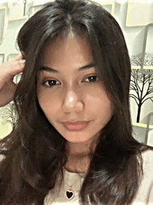a girl with long hair and a heart shaped necklace