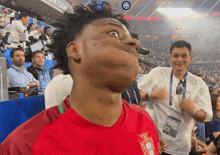 a man making a funny face in front of a scoreboard that says x-0