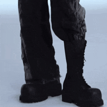 a close up of a person 's feet wearing black boots
