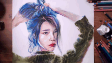 a drawing of a woman with blue hair is on a table with colored pencils