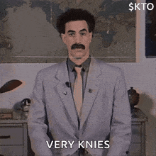 a man in a suit and tie says very knees in front of a map