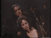 a man is holding a woman 's neck in a dark room in a movie .