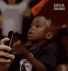 a young boy is screaming in a crowd with diva bible written on the bottom