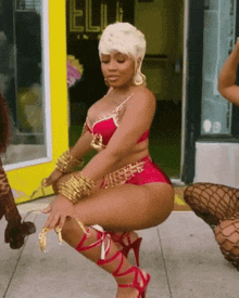 a woman in a red bra and shorts is kneeling down
