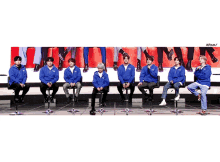 a group of people sitting in a row with the letters aram on the bottom right