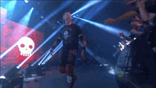 a man in a black shirt with a skull on it is walking through a crowd