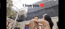 a woman is hugging a man in front of a building that says pbi pro