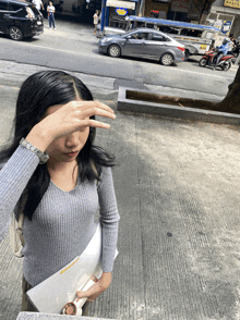 a woman covering her face with her hand in front of a sign that says ' apollo '