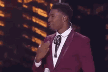 a man in a red suit and tie is giving a thumbs up .