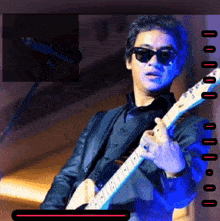 a man in sunglasses is playing a guitar