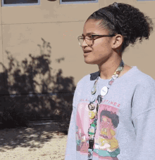 a girl wearing glasses and a sweater that says ' clara martinez ' on it