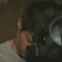 a man in a grey shirt looks at the camera