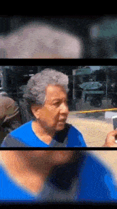 a man in a blue shirt is taking a picture of another man with a cell phone