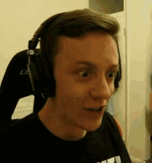 a young man wearing headphones is making a funny face .
