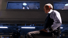 a man sitting in a dark room with a gun