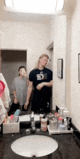 a man and a woman are taking a selfie in a bathroom mirror