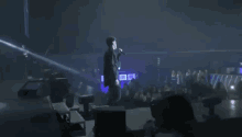 a woman is taking a picture of a man on stage with her phone