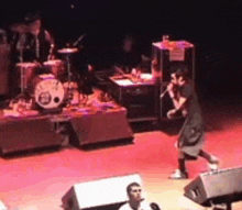 a man is singing into a microphone on a stage while another man watches .