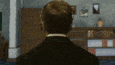 a man wearing headphones stands in front of a book shelf