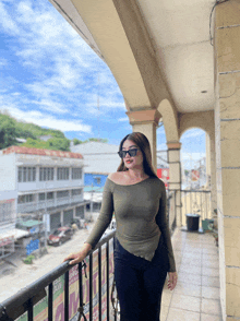 a woman wearing sunglasses stands on a balcony with a sign that says ' attorney ' on it