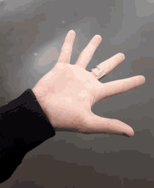 a person 's hand with a silver ring on it