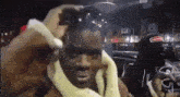 a man wearing a yellow scarf around his neck is being photographed by a person .