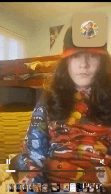 a young girl wearing a hat and a sweater with a cartoon character on it