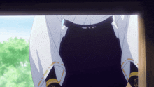a person in a white shirt and black pants is looking out a window