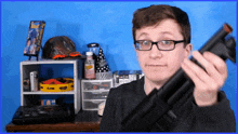 a man holding a gun in front of a blue background