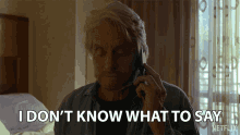 a man talking on a cell phone with the words " i don 't know what to say " behind him