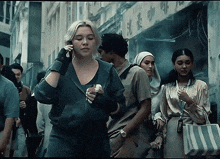 a woman talking on a cell phone while walking down a crowded street