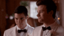 two men in tuxedos and bow ties are smiling