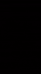 a black panther with bright yellow eyes is walking through a dark forest