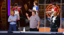 a group of people are standing in front of a masterchef sign
