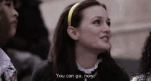 a woman wearing a yellow headband is smiling and saying `` you can go now '' .