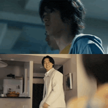 a man in a blue shirt is standing in a kitchen