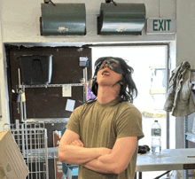 a man standing in front of a green exit sign