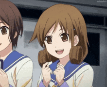 a girl with brown hair is smiling while standing next to another girl with brown hair