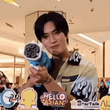 a young man is holding a toy gun in his hand .
