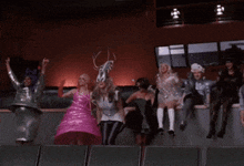 a group of people dressed in costumes are sitting on a ledge