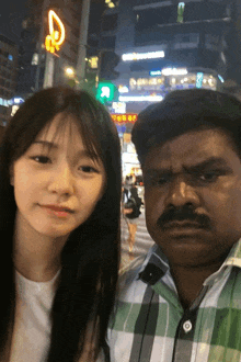a man and a woman are posing for a picture in front of a sign that says r.