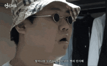 a man wearing a hat and round glasses with korean writing on it