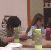a man sits at a table with a bottle of fruity zing