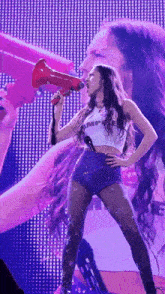 a woman is holding a megaphone in her mouth and singing into it .