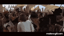 a group of people are standing in a crowd in a movie .