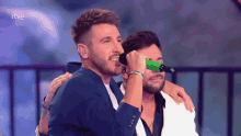two men singing into microphones with rtve written on the bottom right